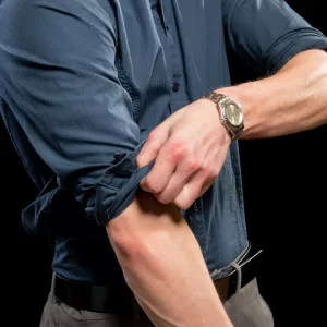 Man rolling up his shirt sleeves.