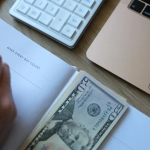 Cash inside a day planner with a calculator to indicate making every dollar count.