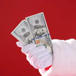 Santa's hand with 100 dollar bills in it.