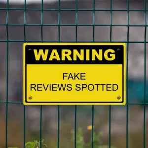 Warning Sign posted on a fence. "Warning: Fake Reviews Spotted"