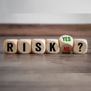 Wooden dice spelling RISK with YES and NO options representing b2b market decision-making challenges