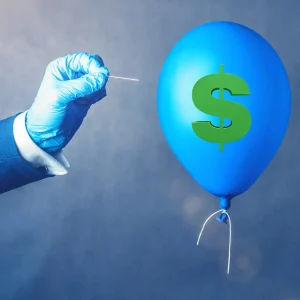 Hand with pin approaching dollar sign balloon illustrating b2b market financial vulnerability